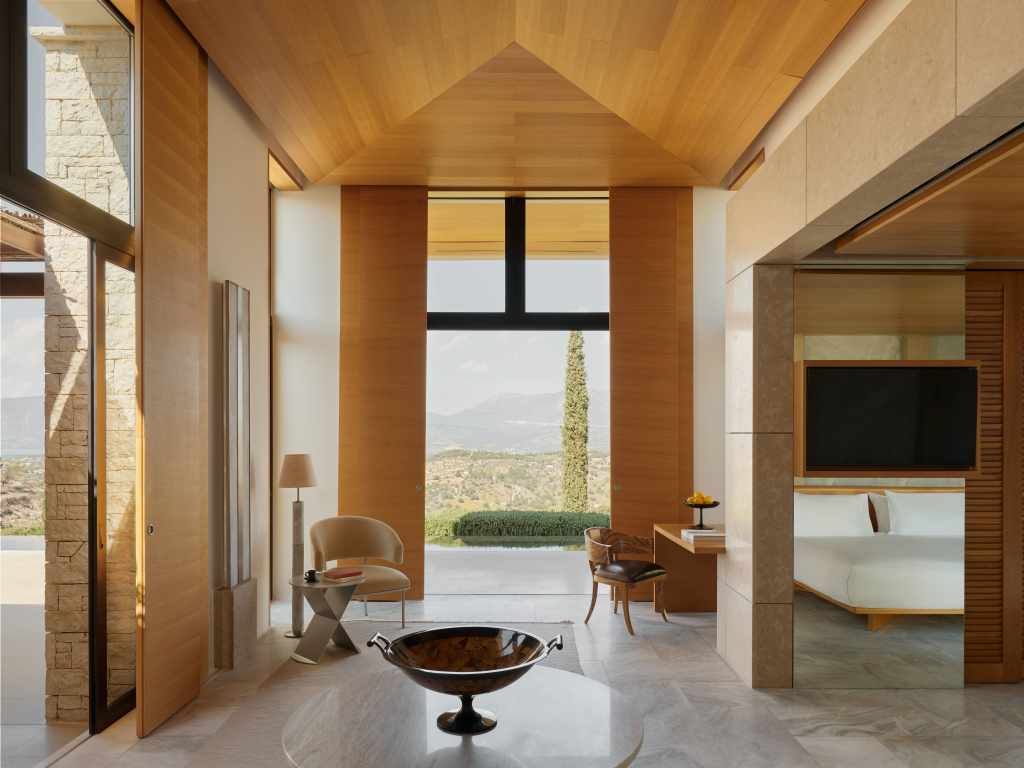 Luxury suite at Amanzoe Greece with king-size bed, private balcony, and sea view