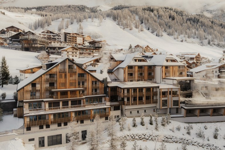 Snow-covered alpine village with luxury ski hotels set against forested mountain slopes, reflecting Europe’s most refined winter resort destinations.