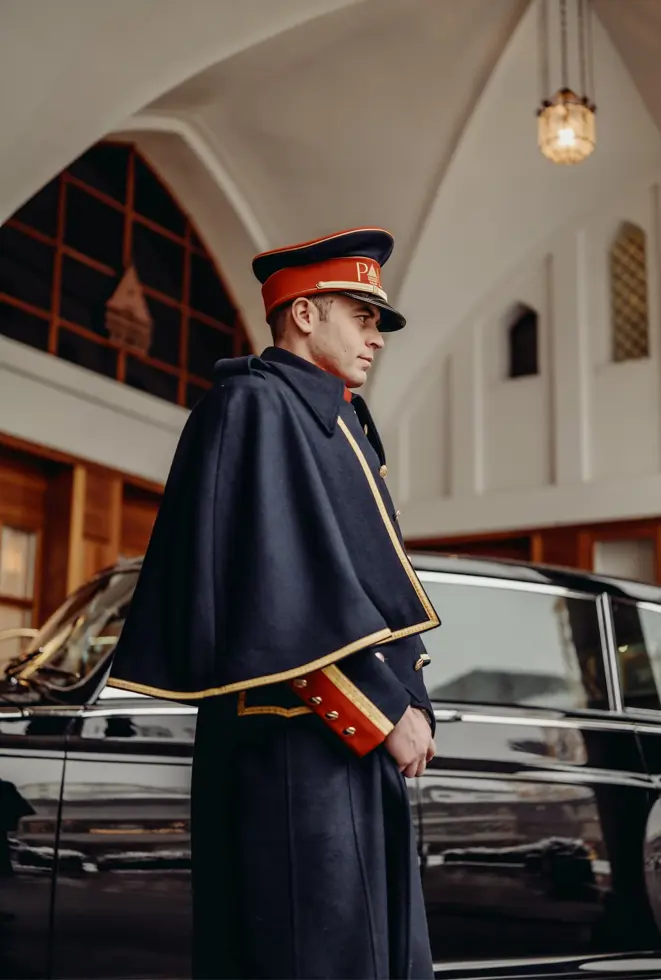 Rolls-Royce chauffeur welcoming guests at the entrance of Badrutt’s Palace Hotel, underscoring the hotel’s heritage of old-world glamour and discreet luxury.