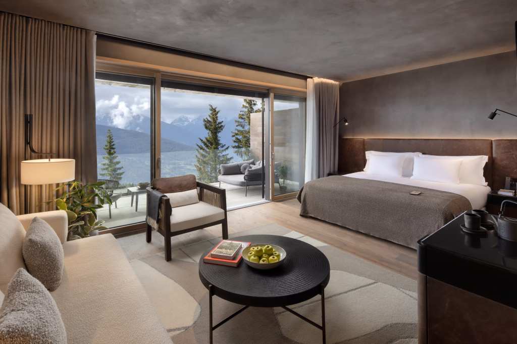 Superior Room at Six Senses Crans-MMontana featuring a private balcony, floor-to-ceiling windows, and panoramic alpine valley views.