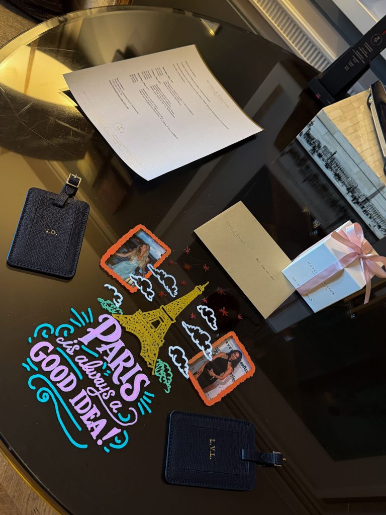 Handwritten-style illustrated welcome note accompanied by monogrammed luggage tags with initials, presented as part of a personalized luxury hotel arrival experience.