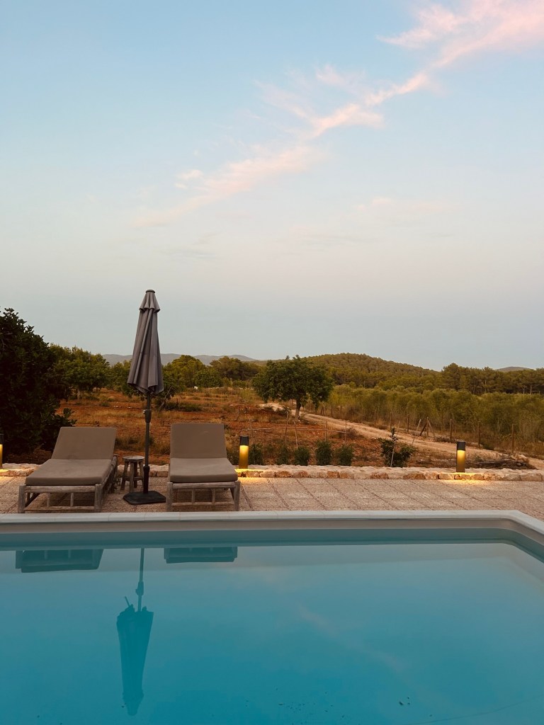 Poolside view of the north Ibiza villa with greenery
