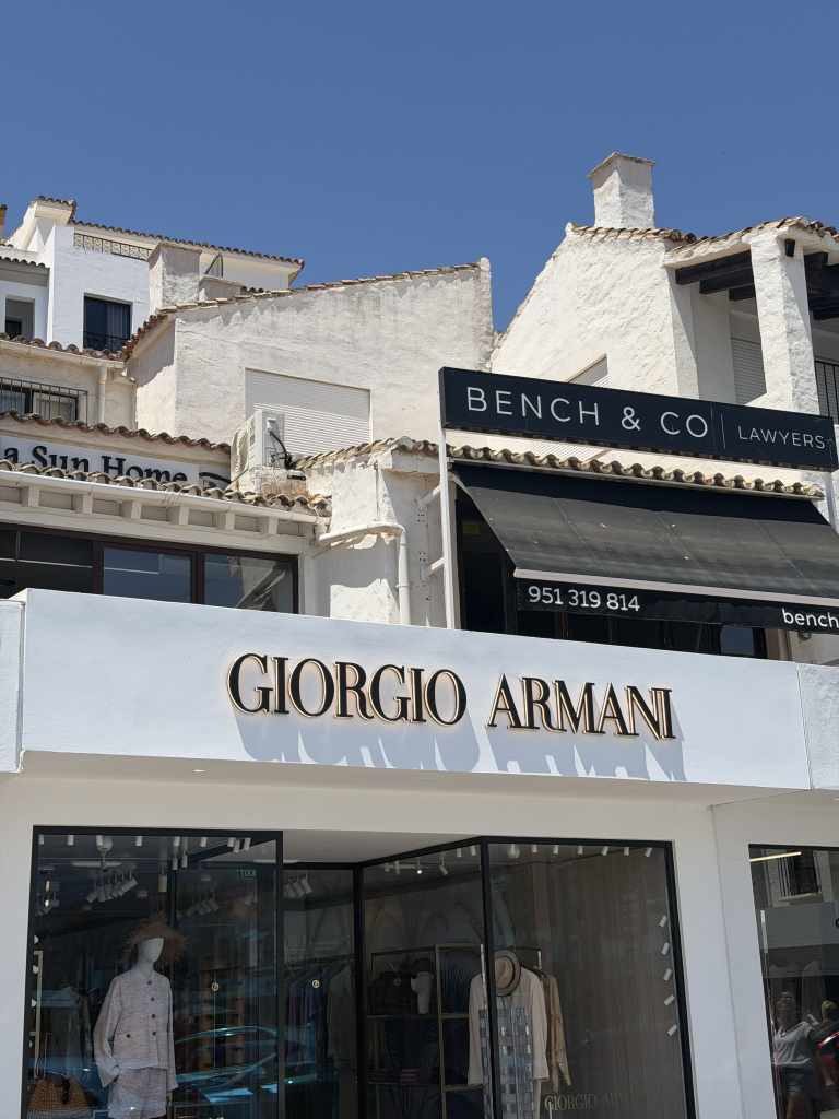 Giorgio Armani boutique in Puerto Banús, Marbella, surrounded by white Mediterranean-style buildings.