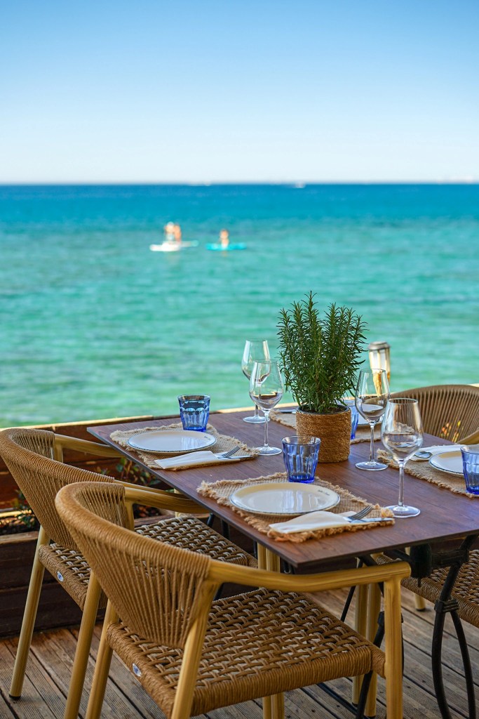Beachfront dining table overlooking the Mediterranean Sea at Victor's Beach in Marbella, Spain.