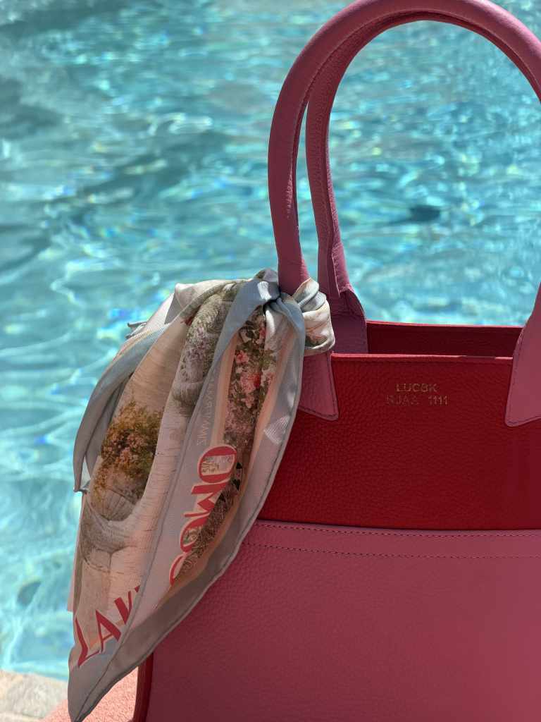 Pink and red LUC8K Tote with a silk scarf beside the turquoise pool at Hôtel Byblos, Saint-Tropez.